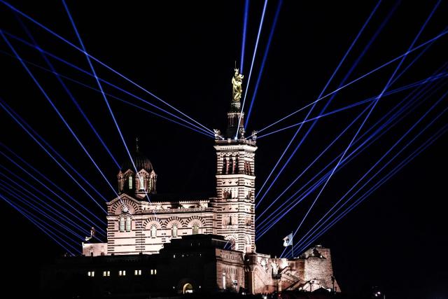 This photograph taken on December 7, 2025 shows a sound and light show origanised to celebrate the inauguration of the statue of the Virgin Mary atop the Basilica of Notre-Dame de la Garde, known to the people of Marseille as Bonne Mere, after its restoration, in Marseille, southern France. (Photo by Thibaud MORITZ / AFP)