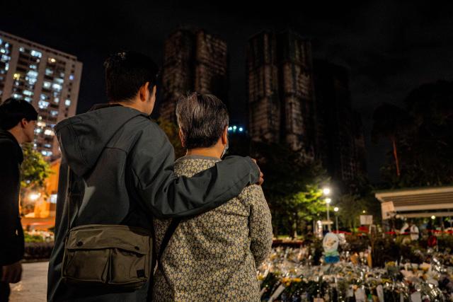 People pay their respects for the victims of a deadly fire at the Wang Fuk Court residential estate in Tai Po district of Hong Kong on December 7, 2025. (Photo by Leung Man Hei / AFP)