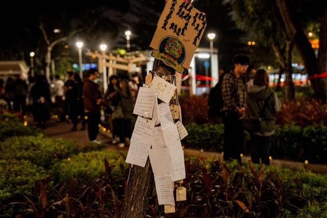 People pay their respects for the victims of a deadly fire at the Wang Fuk Court residential estate in Tai Po district of Hong Kong on December 7, 2025. (Photo by Leung Man Hei / AFP)