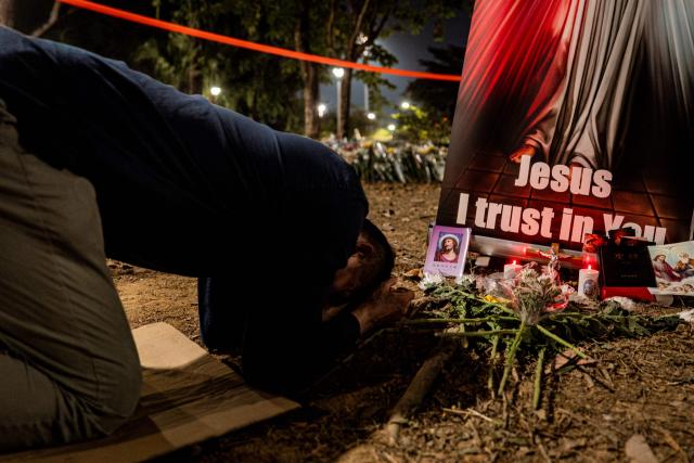 People pay their respects for the victims of a deadly fire at the Wang Fuk Court residential estate in Tai Po district of Hong Kong on December 7, 2025. (Photo by Leung Man Hei / AFP)
