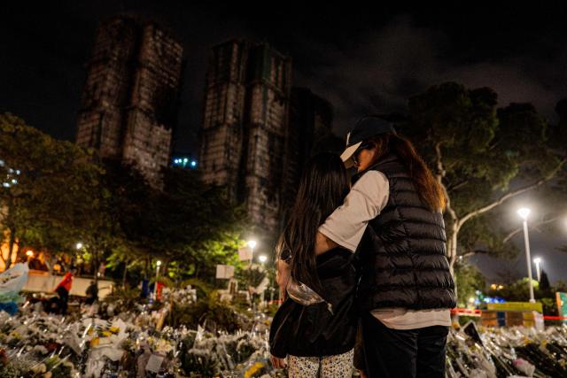 People pay their respects for the victims of a deadly fire at the Wang Fuk Court residential estate in Tai Po district of Hong Kong on December 7, 2025. (Photo by Leung Man Hei / AFP)