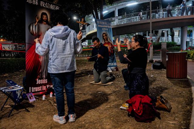 People pay their respects for the victims of a deadly fire at the Wang Fuk Court residential estate in Tai Po district of Hong Kong on December 7, 2025. (Photo by Leung Man Hei / AFP)