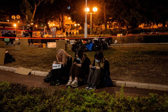 People pay their respects for the victims of a deadly fire at the Wang Fuk Court residential estate in Tai Po district of Hong Kong on December 7, 2025. (Photo by Leung Man Hei / AFP)