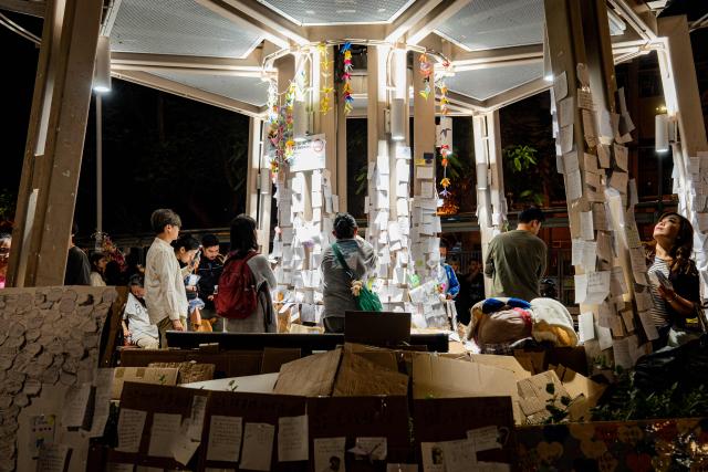 People pay their respects for the victims of a deadly fire at the Wang Fuk Court residential estate in Tai Po district of Hong Kong on December 7, 2025. (Photo by Leung Man Hei / AFP)