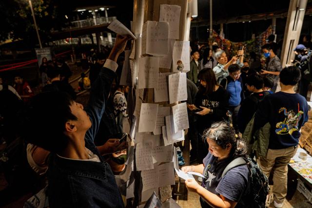People pay their respects for the victims of a deadly fire at the Wang Fuk Court residential estate in Tai Po district of Hong Kong on December 7, 2025. (Photo by Leung Man Hei / AFP)