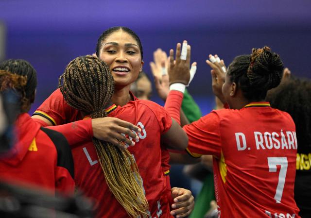 Angola's pivot #10 Albertina Kassoma (C) celebrates after victory with Angola's pivot #05 Liliane Martines Mario (L) and Angola's right wing #07 Dolores Rosario the Group IV main round match between Angola and Sweden of the IHF Women's Handball World Championship in Dortmund, western Germany on December 7, 2025. (Photo by Ina FASSBENDER / AFP)