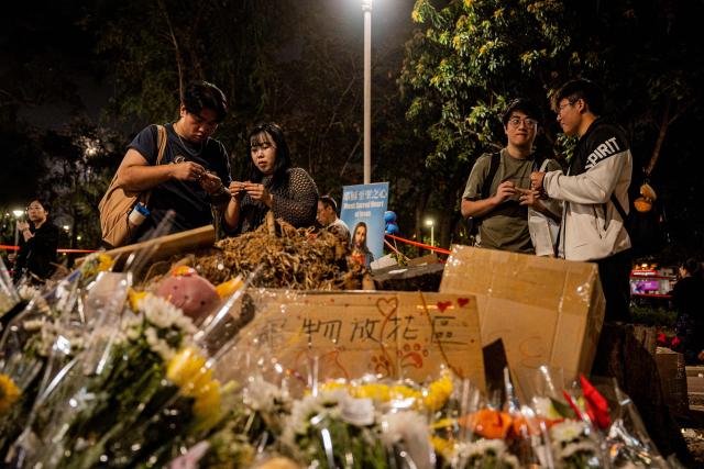 People pay their respects for the victims of a deadly fire at the Wang Fuk Court residential estate in Tai Po district of Hong Kong on December 7, 2025. (Photo by Leung Man Hei / AFP)