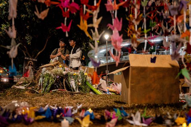 People pay their respects for the victims of a deadly fire at the Wang Fuk Court residential estate in Tai Po district of Hong Kong on December 7, 2025. (Photo by Leung Man Hei / AFP)