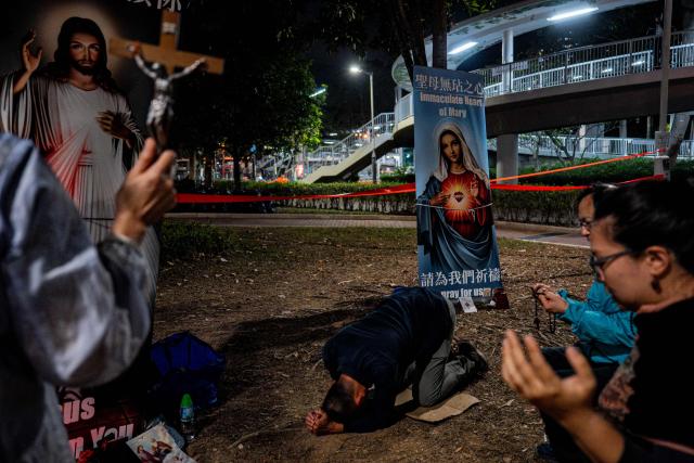 People pay their respects for the victims of a deadly fire at the Wang Fuk Court residential estate in Tai Po district of Hong Kong on December 7, 2025. (Photo by Leung Man Hei / AFP)