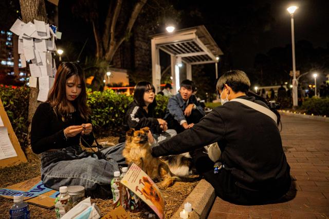 People pay their respects for the victims of a deadly fire at the Wang Fuk Court residential estate in Tai Po district of Hong Kong on December 7, 2025. (Photo by Leung Man Hei / AFP)