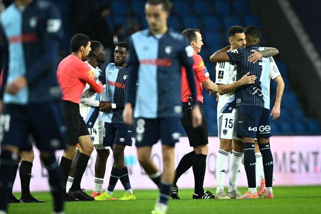 Players hug at the end of the French L1 football match between Le Havre AC and Paris FC at the Oceane stadium in Le Havre, north-western France, on December 7, 2025. (Photo by Lou BENOIST / AFP)