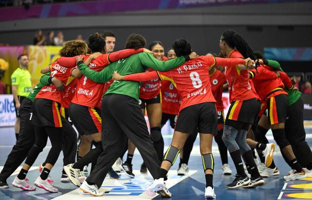 Angola's players celebrate after the Group IV main round match between Angola and Sweden of the IHF Women's Handball World Championship in Dortmund, western Germany on December 7, 2025. (Photo by Ina FASSBENDER / AFP)