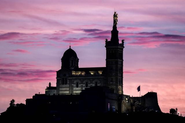 This photograph taken on December 7, 2025 shows the Basilica of Notre-Dame de la Garde, known to the people of Marseille as Bonne Mere, at sunset, in Marseille, southern France. (Photo by Thibaud MORITZ / AFP)
