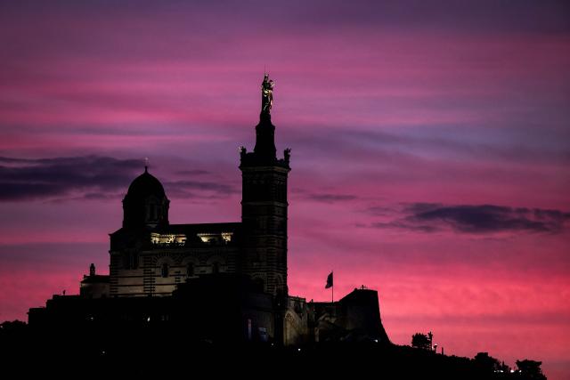 This photograph taken on December 7, 2025 shows the Basilica of Notre-Dame de la Garde, known to the people of Marseille as Bonne Mere, at sunset, in Marseille, southern France. (Photo by Thibaud MORITZ / AFP)
