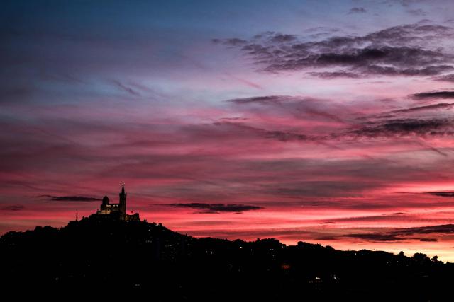 TOPSHOT - This photograph taken on December 7, 2025 shows the Basilica of Notre-Dame de la Garde, known to the people of Marseille as Bonne Mere, at sunset, in Marseille, southern France. (Photo by Thibaud MORITZ / AFP)
