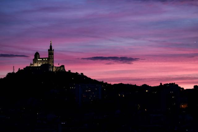 This photograph taken on December 7, 2025 shows the Basilica of Notre-Dame de la Garde, known to the people of Marseille as Bonne Mere, at sunset, in Marseille, southern France. (Photo by Thibaud MORITZ / AFP)