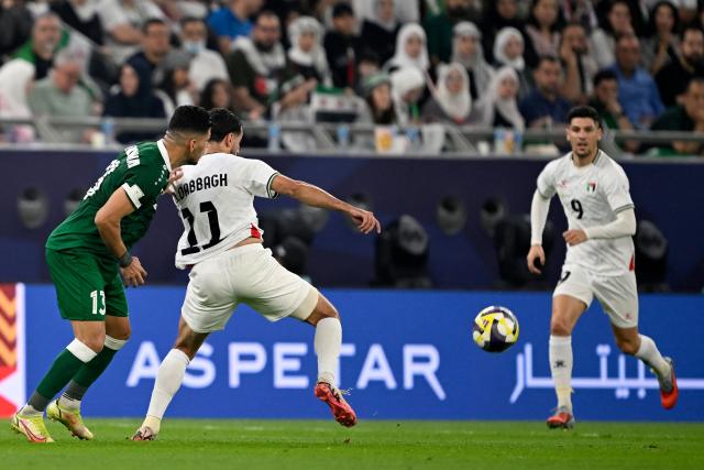 Syria's #13 Abdulrazzak al-Mohammed and Palestine's #11 Oday Dabbagh fight for the ball as Palestine #09 Tamer Seyam  looks on during the FIFA Arab Cup 2025 group stage, Group A, football match between Syria and Palestine, at the Education City Stadium in Al-Rayyan on December 7, 2025. (Photo by Mahmud HAMS / AFP)