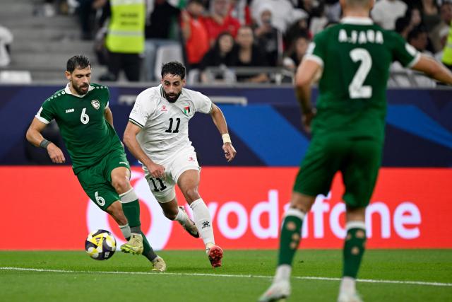 Syria's #06 Khaled Kourdoghli (L) and Palestine's #11 Oday Dabbagh fight for the ball during the FIFA Arab Cup 2025 group stage, Group A, football match between Syria and Palestine, at the Education City Stadium in Al-Rayyan on December 7, 2025. (Photo by Mahmud HAMS / AFP)