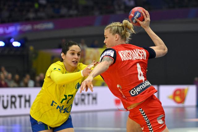 Norway's left back #04 Veronica Kristiansen (R) and Brazil's left back #77 Kelly De Abreu Rosa vie for the ball during the Group IV main round match between Norway and Brazil of the IHF Women's Handball World Championship in Dortmund, western Germany on December 7, 2025. (Photo by INA FASSBENDER / AFP)