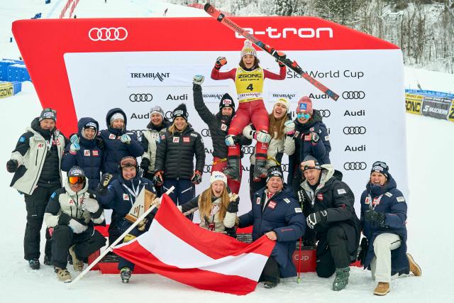 The Austrian team celebrates with first-place winner Julia Scheib (top, in yellow) during the victory celebration for the Women's Giant Slalom event of the FIS Alpine Skiing World Cup in Mont-Tremblant, Quebec, Canada, on December 7, 2025. (Photo by Geoff Robins / AFP)