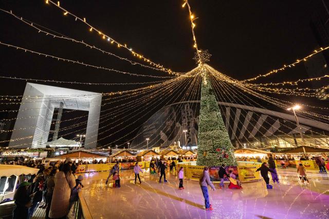 This photograph shows a general view of the ice-skating rink at the Christmas market on the Parvis de la Defense in front of the Grande Arche de la Defense (seen rear), in the business district of La Defense, in Puteaux outside Paris, on December 7, 2025. (Photo by Ian LANGSDON / AFP)