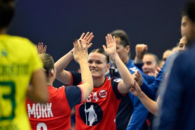 Norway's right back #09 Nora Mork (L) and Norway's wing #34 Anniken Wollik (R) celebrate during the Group IV main round match between Norway and Brazil of the IHF Women's Handball World Championship in Dortmund, western Germany on December 7, 2025. (Photo by INA FASSBENDER / AFP)