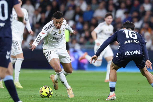 Real Madrid's French forward #10 Kylian Mbappe (L) runs with the ball challenged by Celta Vigo's Spanish midfielder #16 Miguel Roman during the Spanish league football match between Real Madrid CF and RC Celta de Vigo at the Santiago Bernabeu Stadium in Madrid on December 7, 2025. (Photo by Thomas COEX / AFP)