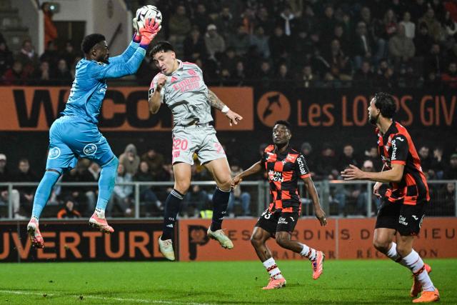 Lorient’s Swiss goalkeeper #38 Yvon Mvogo (L)  catches the ball in front of Lyon’s Uruguayan forward #20 Martin Satriano during the French L1 football match between FC Lorient and Olympique Lyonnais (OL) at the Stade du Moustoir stadium in Lorient, western France, on December 7, 2025. (Photo by Damien Meyer / AFP)