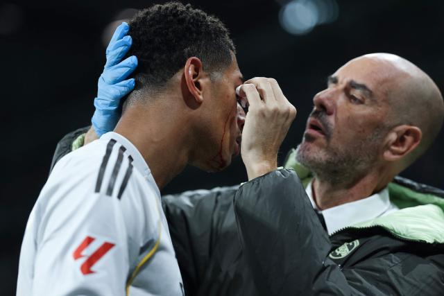 A medic attends to Real Madrid's English midfielder #05 Jude Bellingham after he was injured during the Spanish league football match between Real Madrid CF and RC Celta de Vigo at the Santiago Bernabeu Stadium in Madrid on December 7, 2025. (Photo by Thomas COEX / AFP)