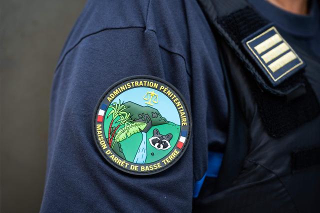 This photograph shows the official patch of the newly inaugurated detention center of Basse-Terre in the French archipelago of Guadeloupe, on December 7, 2025. The French Minister of Justice inaugurated on December 7, 2025 in Basse-Terre, the prefecture of the Guadeloupe archipelago, the new detention center that had been under construction for several years. (Photo by Carla Bernhardt / AFP)