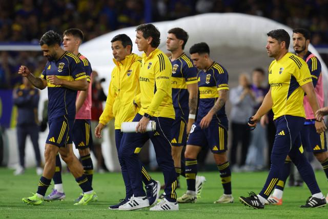 Boca Juniors' head coach Claudio Ubeda (C) and his players leave the pitch after losing the Argentine Professional Football League 2025 Clausura Tournament semifinal match between Boca Juniors and Racing at La Bombonera Stadium in Buenos Aires on December 7, 2025. (Photo by ALEJANDRO PAGNI / AFP)