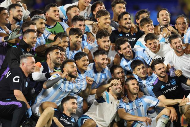 Racing players celebrate after winning the Argentine Professional Football League 2025 Clausura Tournament semifinal match between Boca Juniors and Racing at La Bombonera Stadium in Buenos Aires on December 7, 2025. (Photo by ALEJANDRO PAGNI / AFP)