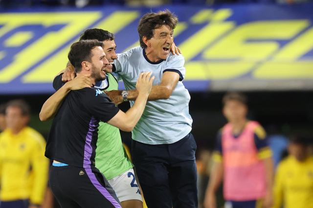 Racing's head coach Gustavo Costas (R) celebrates with his players after winning the Argentine Professional Football League 2025 Clausura Tournament semifinal match between Boca Juniors and Racing at La Bombonera Stadium in Buenos Aires on December 7, 2025. (Photo by ALEJANDRO PAGNI / AFP)