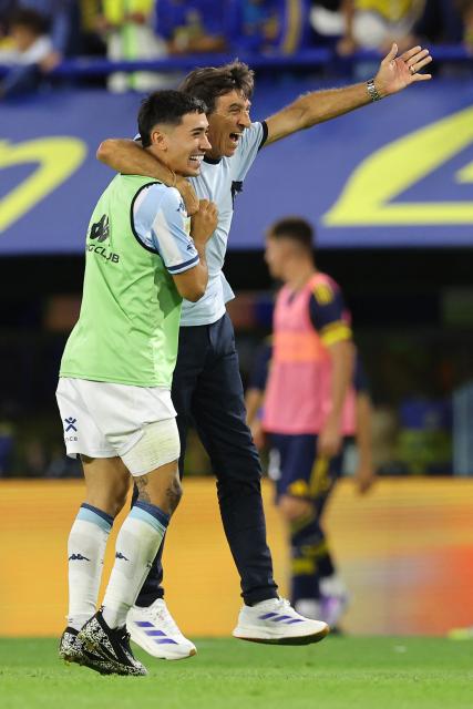 Racing's head coach Gustavo Costas (R) celebrates with forward #28 Santiago Solari after winning the Argentine Professional Football League 2025 Clausura Tournament semifinal match between Boca Juniors and Racing at La Bombonera Stadium in Buenos Aires on December 7, 2025. (Photo by ALEJANDRO PAGNI / AFP)