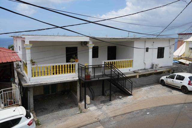 This photograph shows a house a year after the cyclone Chido in the village of Sada, on the French Indian Ocean territory of Mayotte, on December 5, 2025. One year after Cyclone Chido devastated the Indian Ocean archipelago, ‘nothing has been done,’ laments one resident. "Thousands of affected households remain without adequate and decent housing," warns the Housing Foundation. (Photo by Marine GACHET / AFP)