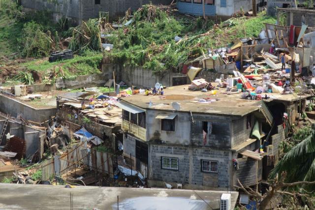 This photograph shows damaged houses following the cyclone Chido in the village of Sada, on the French Indian Ocean territory of Mayotte, on December 15, 2024. One year after Cyclone Chido devastated the Indian Ocean archipelago, ‘nothing has been done,’ laments one resident. "Thousands of affected households remain without adequate and decent housing," warns the Housing Foundation. (Photo by Marine GACHET / AFP)
