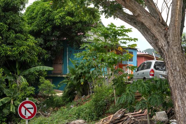 This photograph shows a house a year after the cyclone Chido in the village of Sada, on the French Indian Ocean territory of Mayotte, on December 5, 2025. One year after Cyclone Chido devastated the Indian Ocean archipelago, ‘nothing has been done,’ laments one resident. "Thousands of affected households remain without adequate and decent housing," warns the Housing Foundation. (Photo by Marine GACHET / AFP)