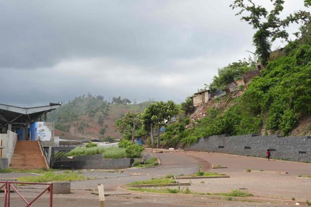 This photograph shows a hill a year after the cyclone Chido in the village of Tsoundzou 1, in Mamoudzou, on the French Indian Ocean territory of Mayotte, on December 5, 2025. One year after Cyclone Chido devastated the Indian Ocean archipelago, ‘nothing has been done,’ laments one resident. "Thousands of affected households remain without adequate and decent housing," warns the Housing Foundation. (Photo by Marine GACHET / AFP)