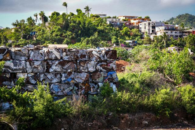 This photograph shows a plot of land filled with debris from houses and metal sheets following the 2024 Cyclone Chido, in Mamoudzou, on the French Indian Ocean territory of Mayotte, on December 2, 2025. Chido, the most devastating cyclone to hit Mayotte in the last 90 years, hit France's poorest department on December 14, 2024, causing colossal damage. (Photo by Marine GACHET / AFP)