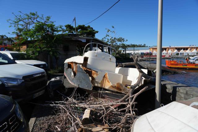 This photograph shows a boat wreck on the sea front following the 2024 Cyclone Chido, in Mamoudzou, on the French Indian Ocean territory of Mayotte, on December 3, 2025. Chido, the most devastating cyclone to hit Mayotte in the last 90 years, hit France's poorest department on December 14, 2024, causing colossal damage. (Photo by Marine GACHET / AFP)