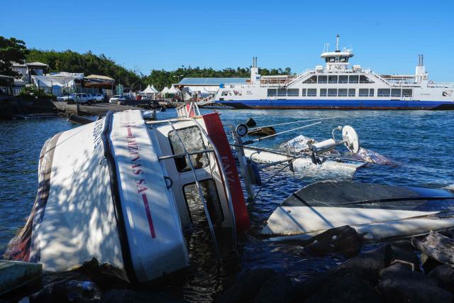 This photograph shows capsized boat wrecks near the shore following the 2024 Cyclone Chido, in Mamoudzou, on the French Indian Ocean territory of Mayotte, on December 3, 2025. Chido, the most devastating cyclone to hit Mayotte in the last 90 years, hit France's poorest department on December 14, 2024, causing colossal damage. (Photo by Marine GACHET / AFP)