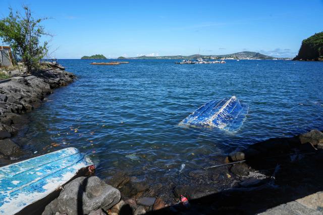 This photograph shows capsized boat wrecks near the shore following the 2024 Cyclone Chido, in Mamoudzou, on the French Indian Ocean territory of Mayotte, on December 3, 2025. Chido, the most devastating cyclone to hit Mayotte in the last 90 years, hit France's poorest department on December 14, 2024, causing colossal damage. (Photo by Marine GACHET / AFP)