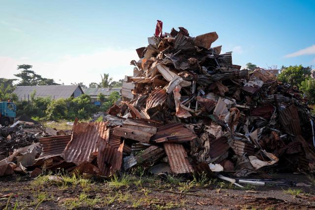 This photograph shows a plot of land filled with debris and metal sheets following the 2024 Cyclone Chido, in Coconi, on the French Indian Ocean territory of Mayotte, on December 3, 2025. Chido, the most devastating cyclone to hit Mayotte in the last 90 years, hit France's poorest department on December 14, 2024, causing colossal damage. (Photo by Marine GACHET / AFP)