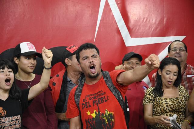 Supporters of Honduran presidential candidate Rixi Moncada of the ruling Libertad y Refundación (LIBRE) party attend a press conference at the Libre Party branch in Tegucigalpa on December 7, 2025. The release of the vote count from the presidential elections held a week ago in Honduras remained stalled this Sunday for the second consecutive day, according to an electoral authority and one of the candidates. (Photo by Orlando SIERRA / AFP)