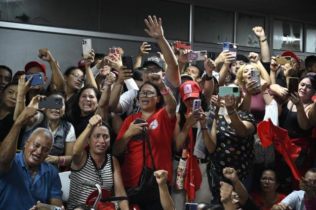 Supporters of Honduran presidential candidate Rixi Moncada of the ruling Libertad y Refundación (LIBRE) party attend a press conference at the Libre Party branch in Tegucigalpa on December 7, 2025. The release of the vote count from the presidential elections held a week ago in Honduras remained stalled this Sunday for the second consecutive day, according to an electoral authority and one of the candidates. (Photo by Orlando SIERRA / AFP)