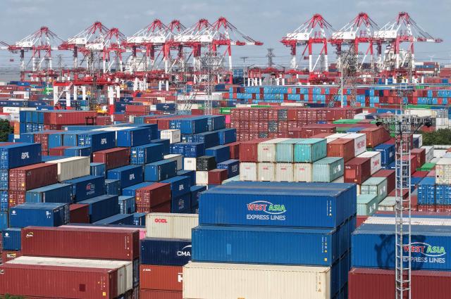 An aerial view shows stacked containers at the Shanghai Port container terminal in Shanghai on December 8, 2025. China's exports grew faster than expected last month, official data showed on December 8, returning to growth after sliding in October despite a sharp drop in shipments to the United States. (Photo by -STR / AFP) / China OUT