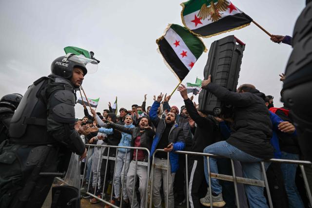 TOPSHOT - People wave Syrian flags as they celebrate a year since the ousting of longtime ruler Bashar al-Assad in the Syrian capital Damascus on December 8, 2025. President Ahmed al-Sharaa on December 8 urged Syrians to work together to rebuild their country as they marked a year since the ousting of longtime ruler Bashar al-Assad. Sharaa's Islamist-led alliance launched a lightning offensive in late November last year, taking the capital Damascus on December 8 after nearly 14 years of war and putting an end to more than five decades of the Assad family's iron-fisted rule. (Photo by LOUAI BESHARA / AFP)