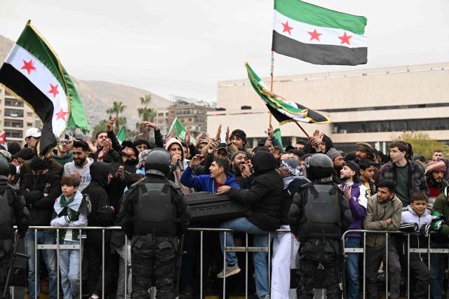 People gather to celebrate a year since the ousting of longtime ruler Bashar al-Assad in the Syrian capital Damascus on December 8, 2025. President Ahmed al-Sharaa on December 8 urged Syrians to work together to rebuild their country as they marked a year since the ousting of longtime ruler Bashar al-Assad. Sharaa's Islamist-led alliance launched a lightning offensive in late November last year, taking the capital Damascus on December 8 after nearly 14 years of war and putting an end to more than five decades of the Assad family's iron-fisted rule. (Photo by LOUAI BESHARA / AFP)