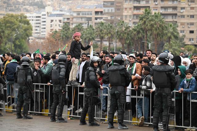 People gather to celebrate a year since the ousting of longtime ruler Bashar al-Assad in the Syrian capital Damascus on December 8, 2025. President Ahmed al-Sharaa on December 8 urged Syrians to work together to rebuild their country as they marked a year since the ousting of longtime ruler Bashar al-Assad. Sharaa's Islamist-led alliance launched a lightning offensive in late November last year, taking the capital Damascus on December 8 after nearly 14 years of war and putting an end to more than five decades of the Assad family's iron-fisted rule. (Photo by LOUAI BESHARA / AFP)