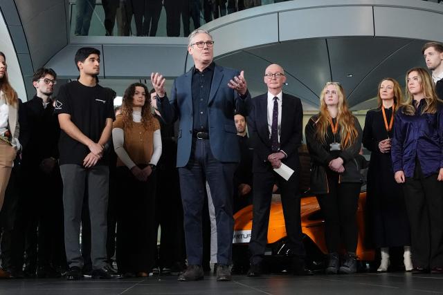 Britain's Prime Minister Keir Starmer (C) speaks during a visit to McLaren Automotive in Woking, Surrey, south-west of London, on December 8, 2025, to announce a major investment in apprenticeships in an effort to tackle rising youth unemployment. (Photo by Jonathan Brady / POOL / AFP)
